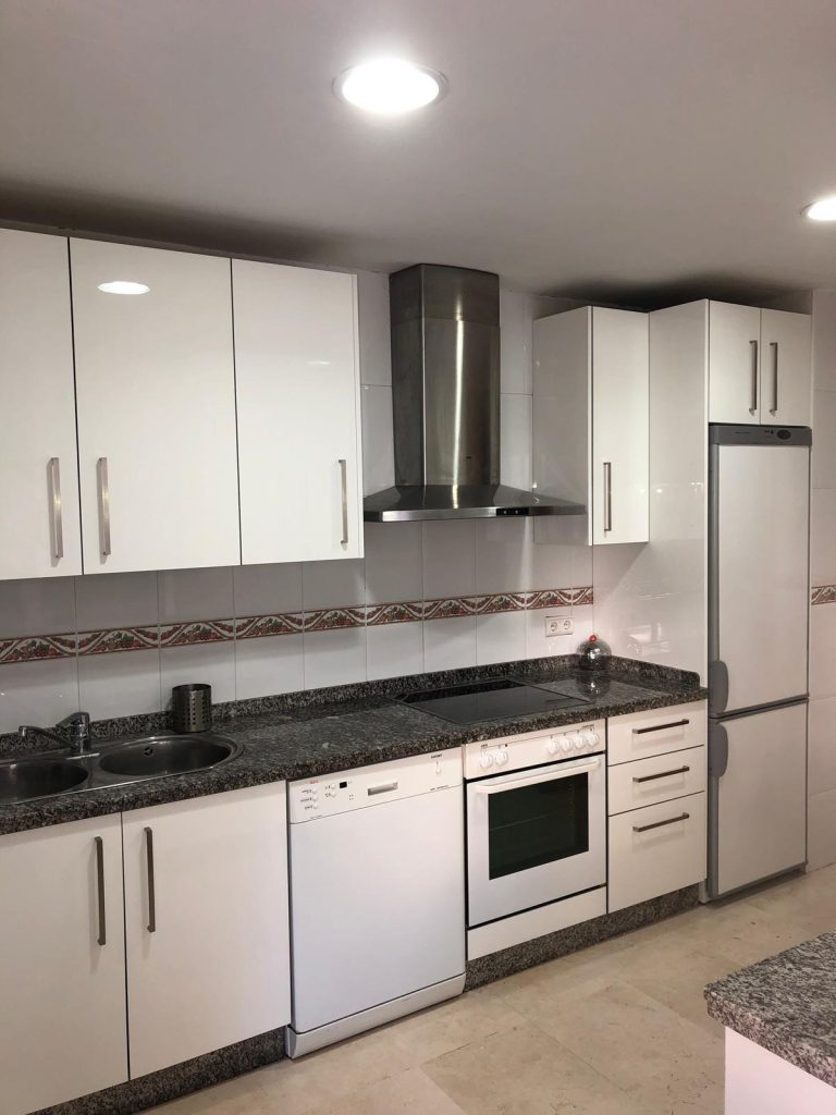 Montaje de cocina completa con muebles blancos y electrodomésticos integrados